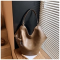 Détail du sac hobo marron vintage avec étui à lunettes suspendu sur des livres - Kaki