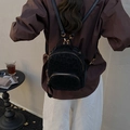 Mini sac à dos noir à imprimé léopard avec fermetures dorées porté par un modèle - Imprimé Léopard Noir