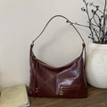 Close-up of vintage burgundy oily leather texture and metal zipper detail on hobo bag - Red