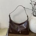 Detail of vintage brown hobo bag with glossy finish and gold-tone metal ring hardware - Brown