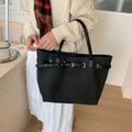 Detail view of black canvas tote bag with leather strap and silver buckle accent - Black