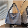 Detail of washed blue denim hobo bag featuring thick strap and black buckle closure - Blue