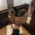 Leopard print crescent bag with rope handle and beaded tassel charm in hand - Leopard Print With Charm