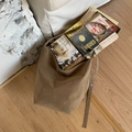 Borsa hobo in camoscio marrone con occhielli in metallo e capienza su pavimento in legno - Cachi