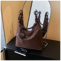 Detail der Leopard-Hobo-Tasche mit Holzperlen-Griffen auf einem Vintage-Schrank - Leopardenmuster