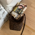 Borsa a secchiello retrò leopardata con tracolla con borchie su sfondo di legno vintage - Marrone