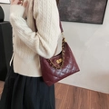 Bolso hobo acolchado rojo oscuro con cadena dorada y cierre de giro en la modelo - Burdeos