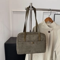Olivgrüne Wildleder-Tragetasche mit runder Schnalle an einem Kleiderbügel hängend - Grün