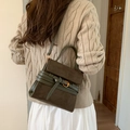 Vintage Umhängetasche aus olivgrünem Wildleder mit goldener Schnalle an einem Model - Grün