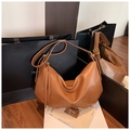 Detailed close-up of brown faux leather hobo bag with moon shape and tassel detail - Brown