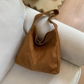 Dettaglio della borsa shopper leopardata con chiusura metallica sul divano - Marrone
