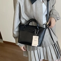 Elegante borsa a mano nera intrecciata con dettagli dorati e tracolla rimovibile - Nero