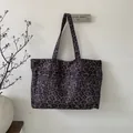 Dettaglio della borsa tote in velluto a coste con stampa leopardata viola e manici - Grigio