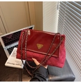 Dettaglio borsa trapuntata rossa con cuciture in vernice e logo metallico triangolare - Rosso