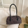 Bolso baguette con estampado de leopardo y correas de cuero negro en sofá blanco - Verde