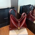 Bolso tote minimalista de charol burdeos con pliegues geométricos y colgante dorado - Burdeos