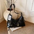 Glossy black patent leather hobo tote bag with gold hardware and white charm detail - Black