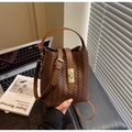 Detailaufnahme der dunkelbraunen geflochtenen Eimer-Tasche mit goldenem Metallverschluss - Braun