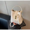Detail der cremefarbenen geflochtenen Beuteltasche mit Goldverschluss und Tragegriff - Cremeweiß
