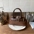 Dettaglio borsa a conchiglia in pelle scamosciata marrone scuro con fibbie metalliche - Marrone