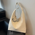 Matte cream large tote bag with shoulder strap and cylindrical charm on a leather sofa - Off-white