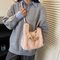 Borsa a tracolla in ecopelliccia rosa con cinturini in pelle indossata da una modella - Rosa