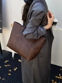 Dark brown leather tote bag with large capacity shown on shoulder of a model in stylish outfit - Brown
