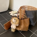 Deep brown woven tote bag set with matching pouch and lion charm in a home setting - With Charm / Brown