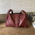 Burgundy faux leather tote bag with vintage buckle strap and silver rivet accents - Red
