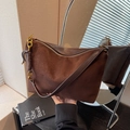 Deep brown suede shoulder bag with gold zipper and leather knot detail for women - Coffee