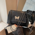 Borsa a tracolla trapuntata nera con farfalla argentata e catena metallica fine - Nero