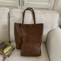 Donkerbruine leren shopper en klein tasje set op een witte bank van stof - Bruin