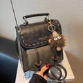 Retro black leather backpack for women featuring contrast stitching and a brown plush charm - Black with Pendant