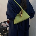Green suede shoulder bag with wooden beads on navy coat for fall winter commute - Green