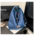 Close-up of blue suede tote bag showing drawstrings and colorful plaid lining fabric - Blue