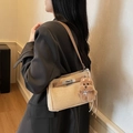 Retro khaki crossbody bag with brown strap and plush bear charm worn by model - With Charm / Khaki