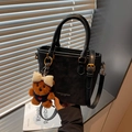 Borsa a secchiello in pelle nera opaca con manico e ciondolo a forma di orsetto di peluche - Nero con ciondolo