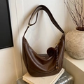 Dark brown crescent crossbody bag with adjustable strap and fluffy pompom charm - Brown