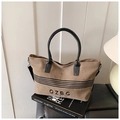 Detail of striped canvas tote bag with black handles and adjustable shoulder strap - Brown