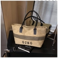 Detailed close-up of striped canvas tote bag with black leather handles and QZBG logo - Khaki