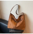 Detalle de un bolso hobo de ante marrón con fina correa de cuero y hebilla metálica - Marrón