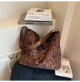 Vista detallada del bolso tote de leopardo con correa de cuero marrón y herrajes de metal - Estampado de leopardo