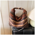 Detalle de bolso hobo de punto con patrón geométrico en tonos naranja cálido y azul marino - Marrón