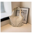 Detail of cream white tote bag featuring metallic silver studs and eyelet embellishments - White