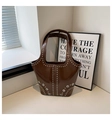 Detailed macro view of the glossy brown leather texture and silver rivets on the tote bag - Coffee