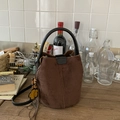 Dettaglio borsa a secchiello in camoscio marrone con ciondolo a fiore e manico in pelle - Caffè Con Pendente