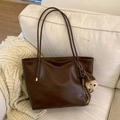 Grande borsa shopper vintage marrone scuro con ciondolo a forma di orso sul divano - Caffè con Ciondolo