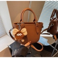 Brown lychee pattern handbag with cute plush charm and adjustable shoulder strap - Brown