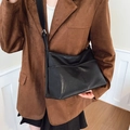 Grande borsa tote in pelle nera con tasche anteriori e tracolla indossata da una modella - Nero