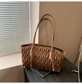 Detail of dark brown tote bag featuring luxury matelasse pleated texture and slender straps - Brown